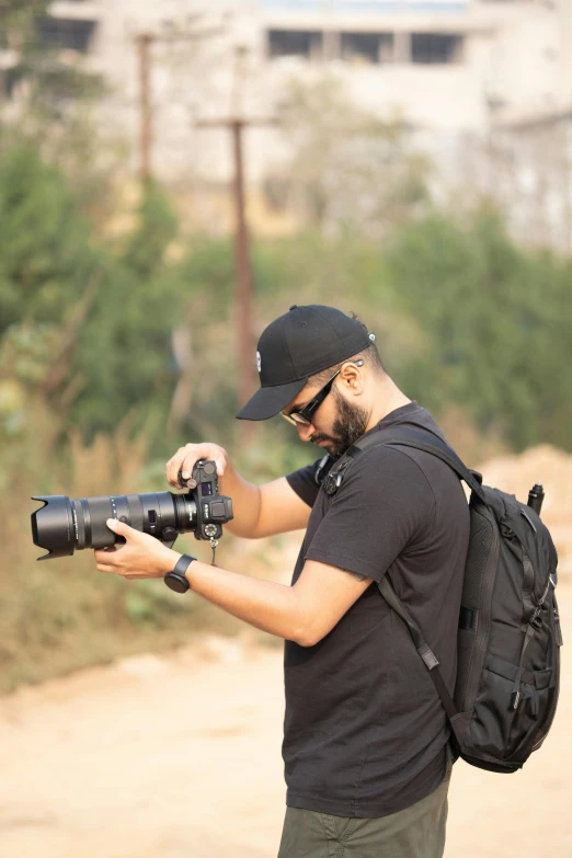 a man in a cap is holding some type of camera