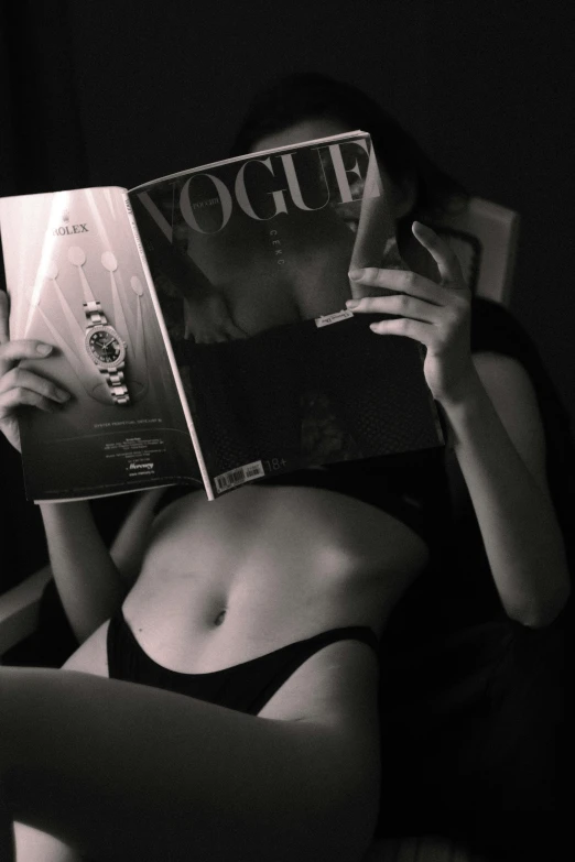woman in black  on bed reading a magazine