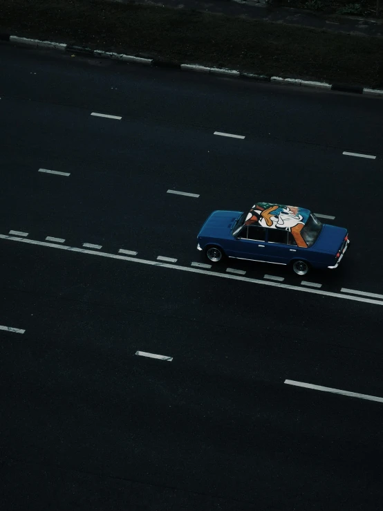 blue and white car traveling down a dark street