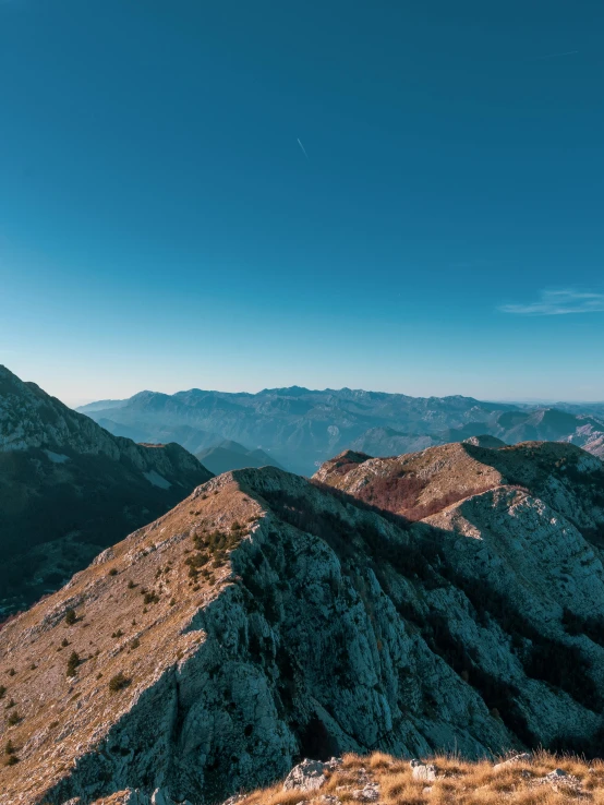 the view looking down into mountains from the top of a hill