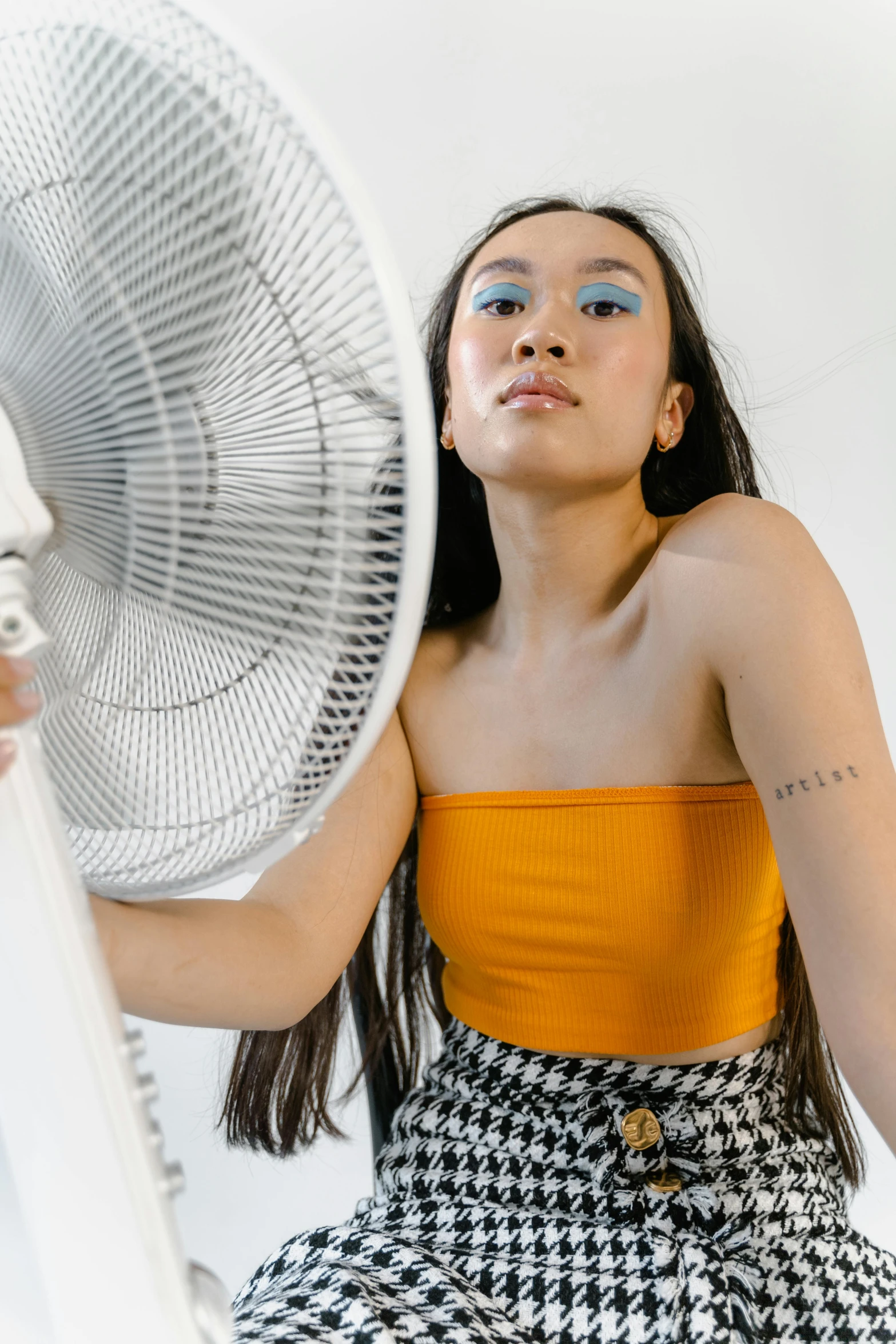 a girl is posing for a picture holding a fan