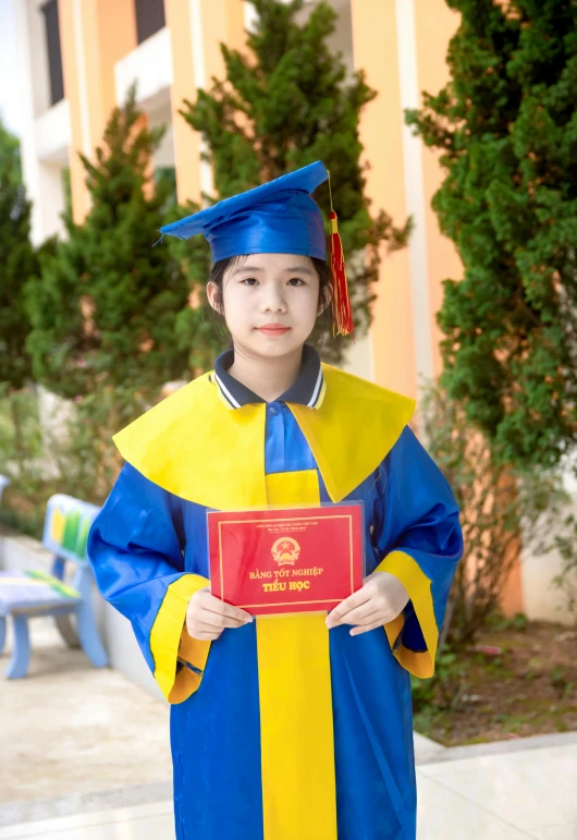 a boy in a graduation gown and cap holds a plaque