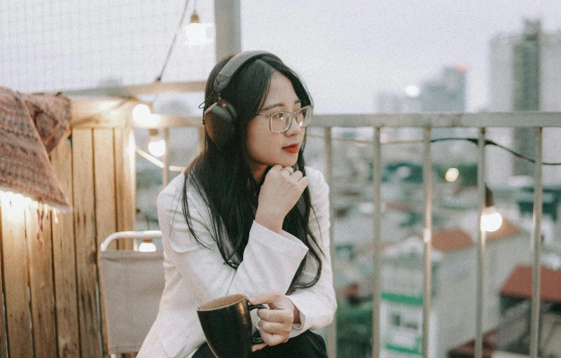 woman with long hair wearing headphones on a rooftop deck