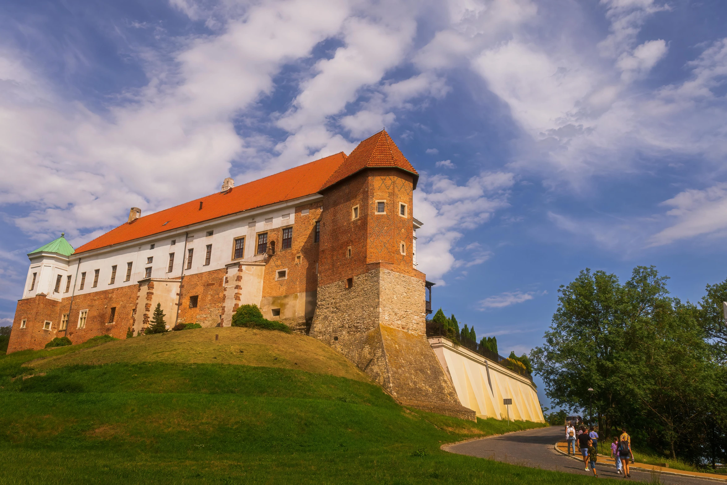 people standing outside a building on a hill