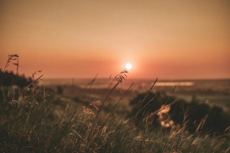 the sun is setting behind the fog in the horizon