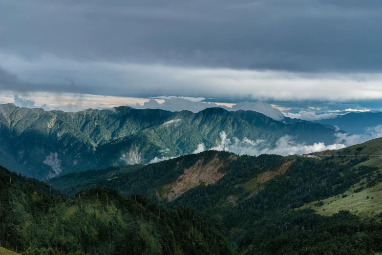 some tall mountains covered in clouds with trees