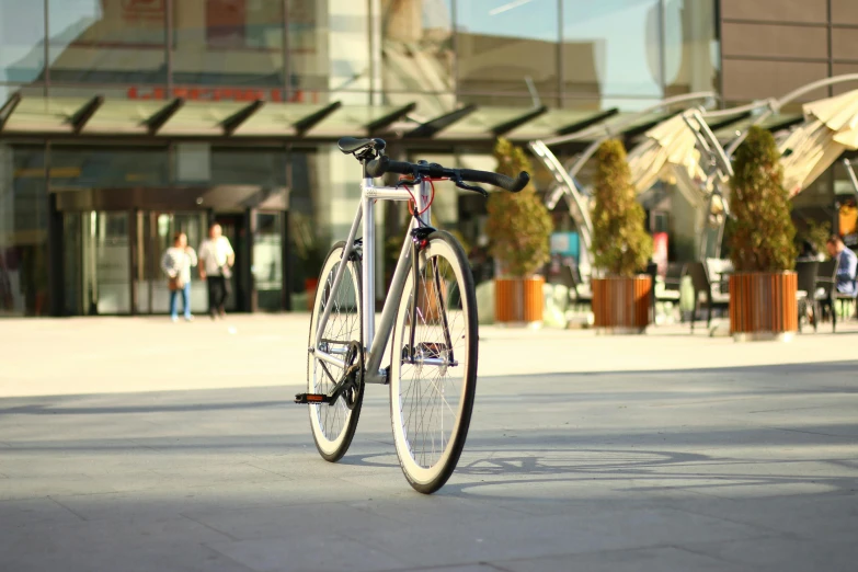 bicycle locked to pole, outside building during daytime