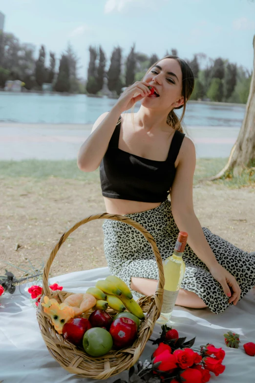 there is a woman sitting down next to a basket of fruit