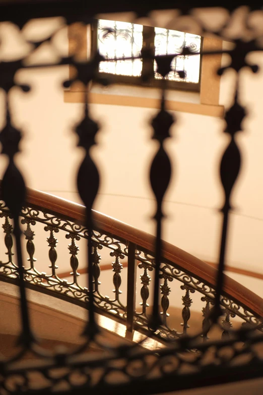 a stairwell railing with a glass window and a person on the floor