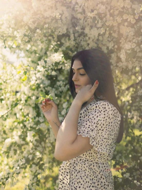 a girl in a polka dot dress is eating from her hand