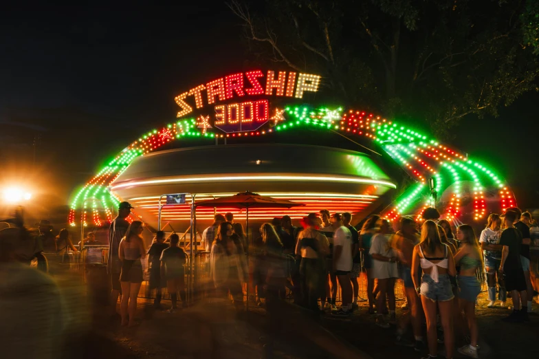 a group of people stand underneath a lighted entrance