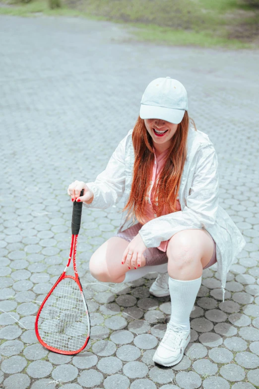 a girl in a hat is playing with a tennis racket