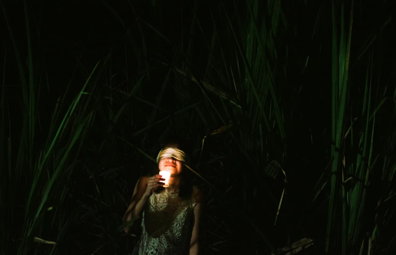 a woman standing in the middle of a dark forest