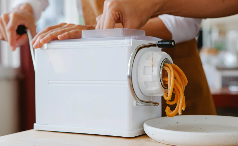 a person is cooking spaghetti in a small white dish