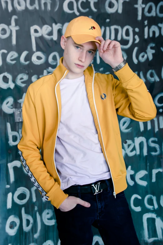 the young man is posing with his hat over his head