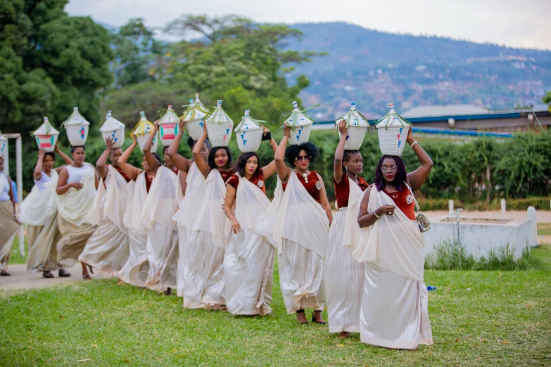 a large group of women carrying vases behind them