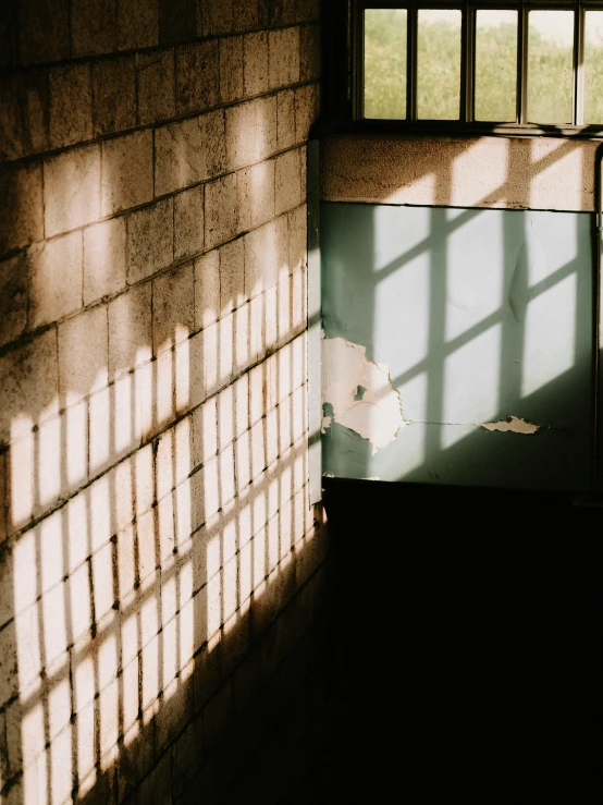 a sunbeam on a brick wall shows off the shadow of a building's front door