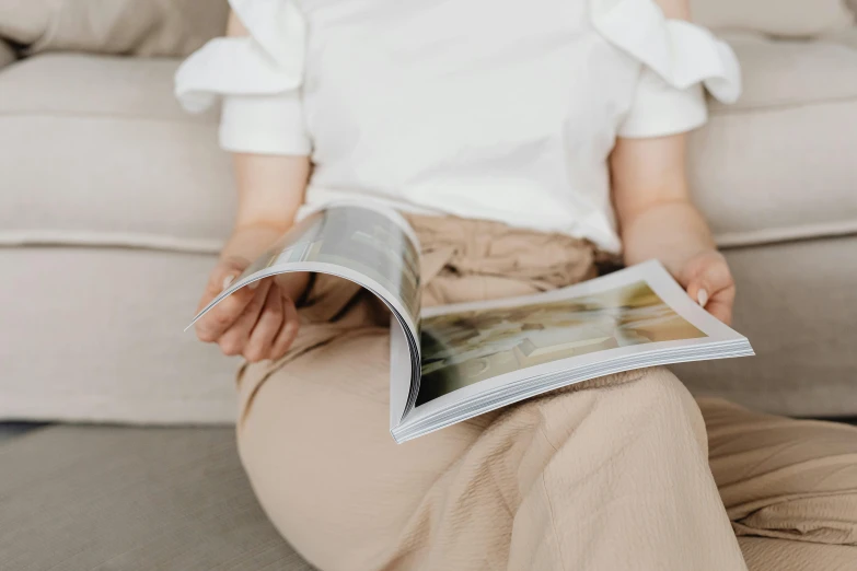 the woman is wearing a white top and beige pants