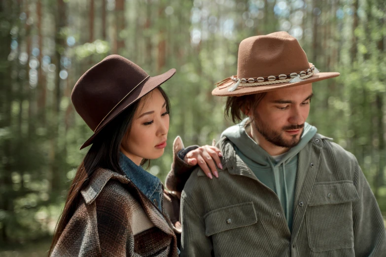 a man and woman walking through a forest