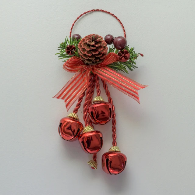 an ornamental ornament with bells made out of twine, and pinecones