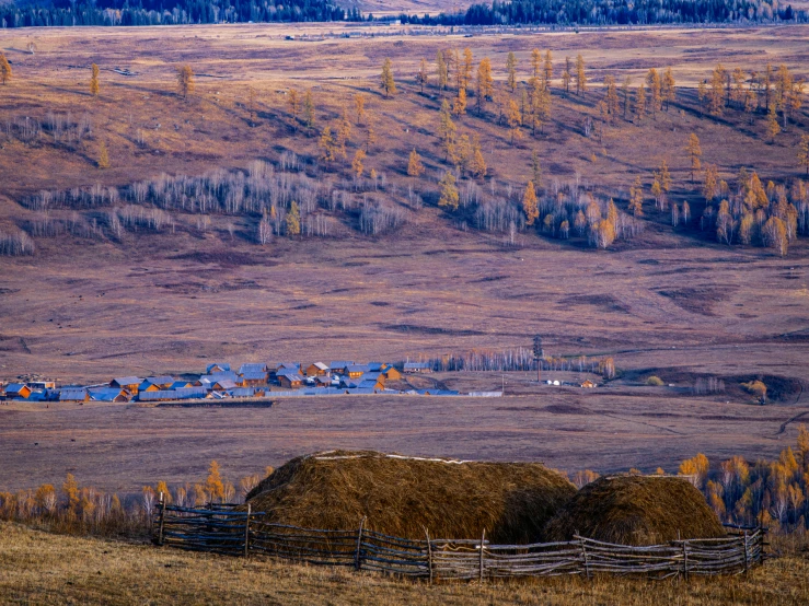 a rural scene with a small town and mountains