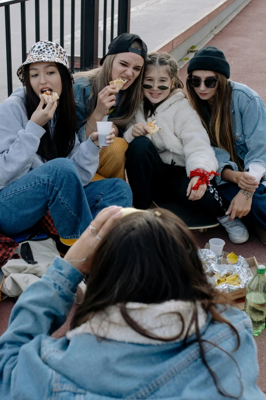 a group of women sitting on the ground eating