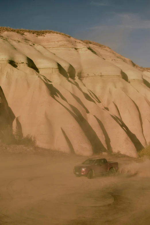 a pickup truck making it way across sand hills