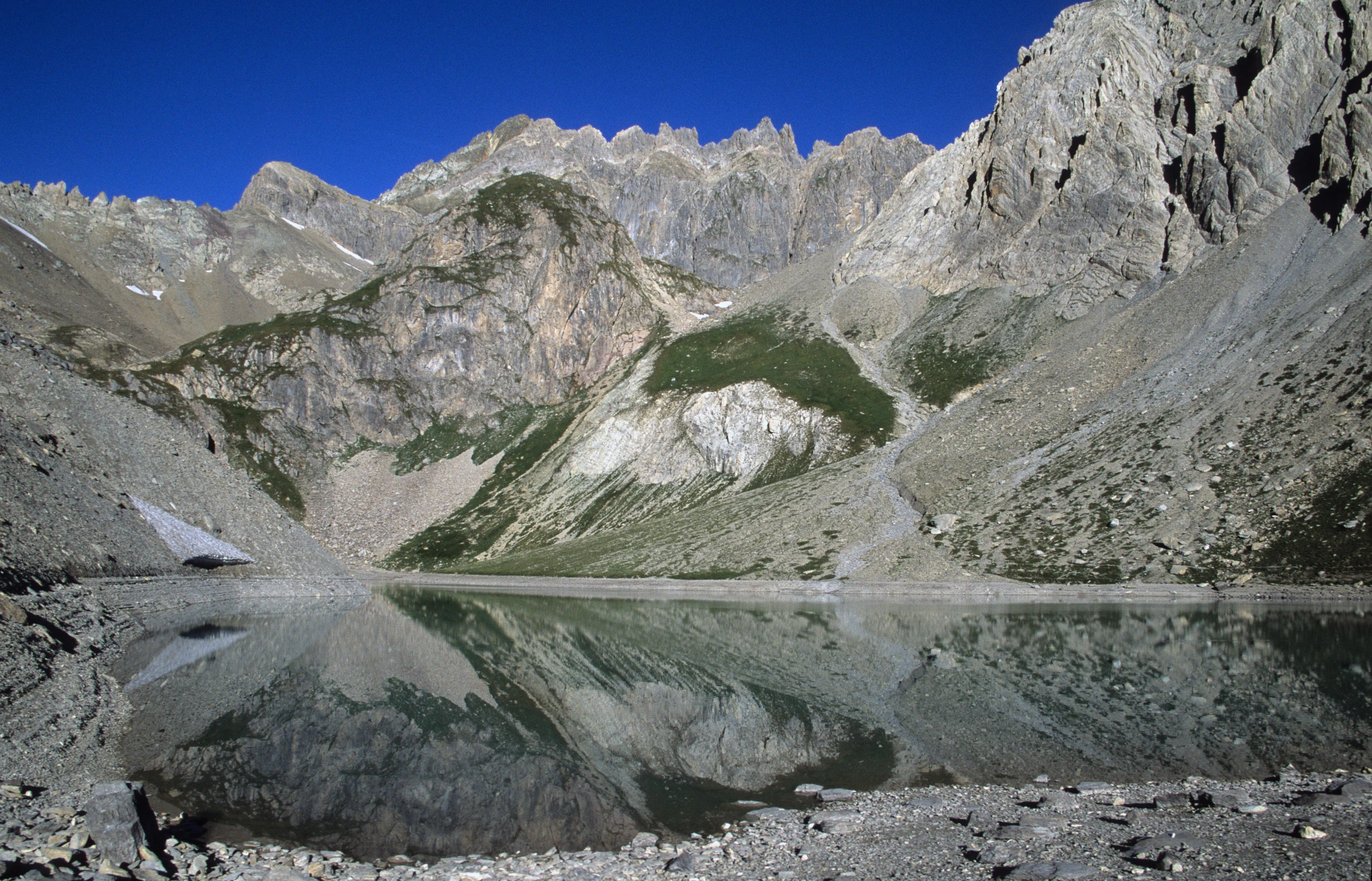 a mountain lake with no clouds in the sky