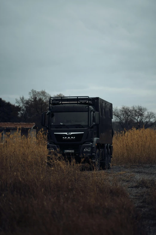 black truck parked in the middle of dry grass