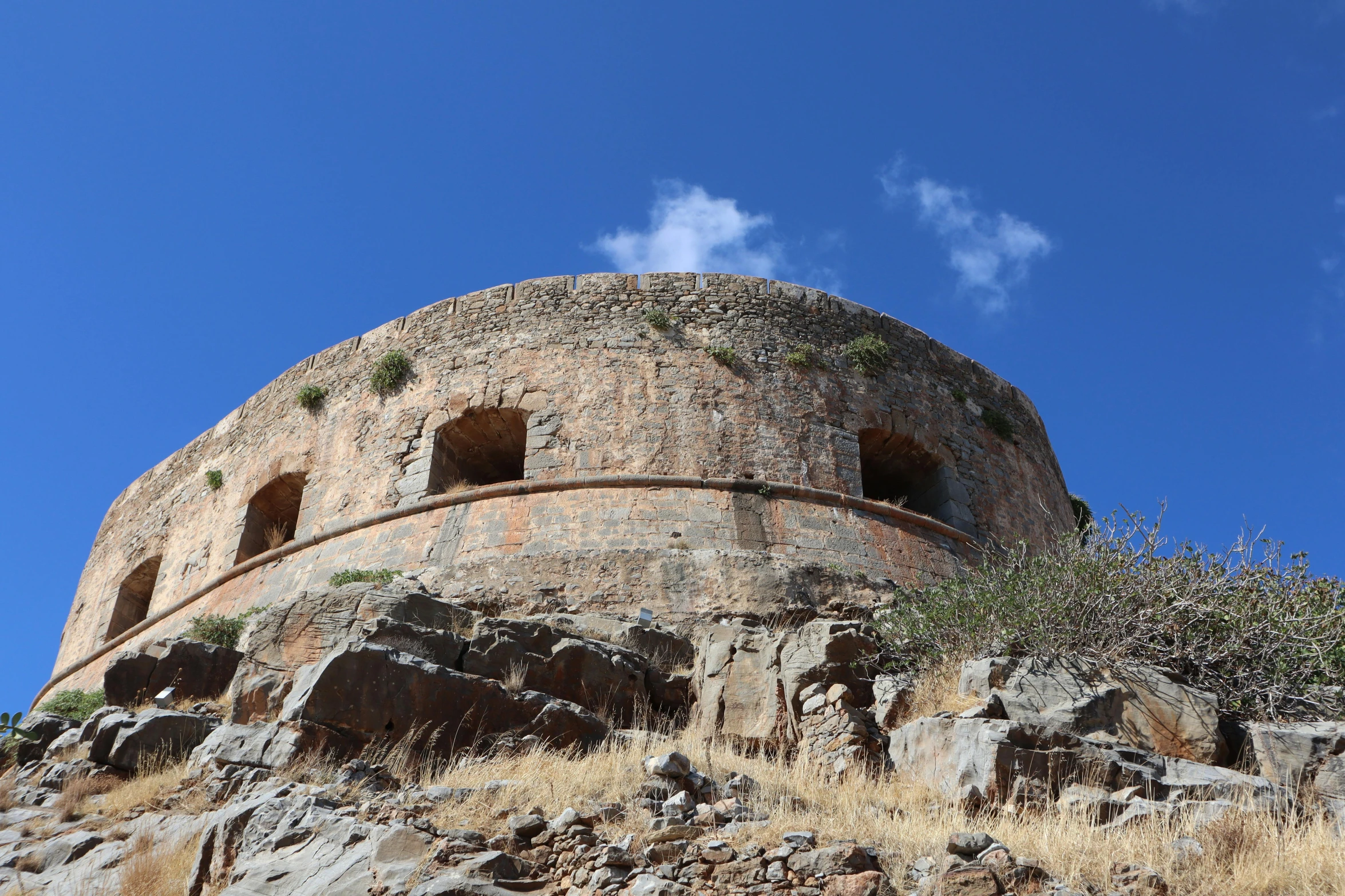 a building made out of rocks on top of a hill