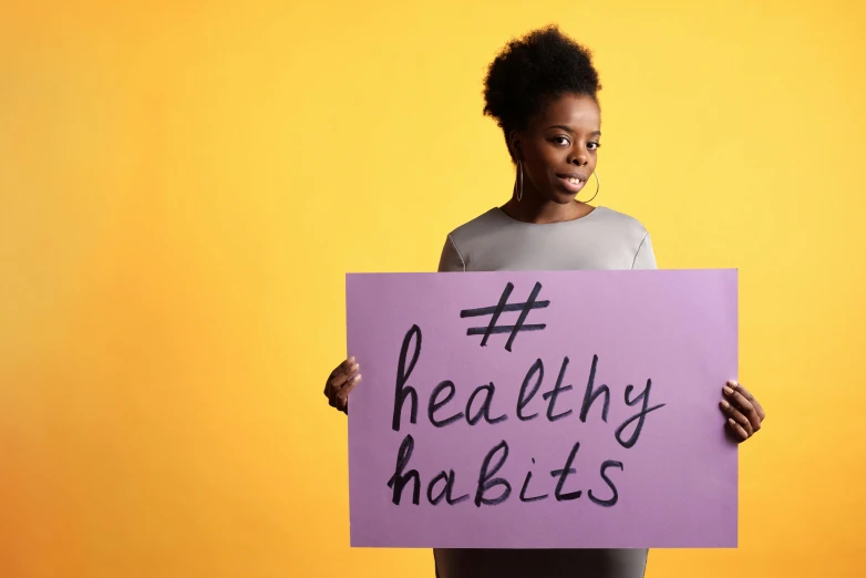 woman holding a purple sign reading healthy habits