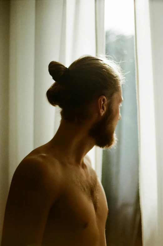 a shirtless man with a large pony tail