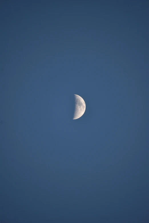 the moon in a clear blue sky with a thin side