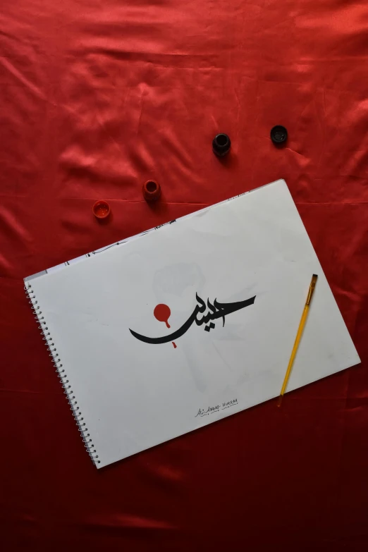 a po of a red sheet with a notepad, marker and eraser