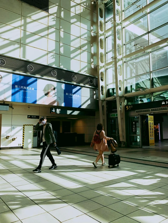 the people walk through an empty airport terminal