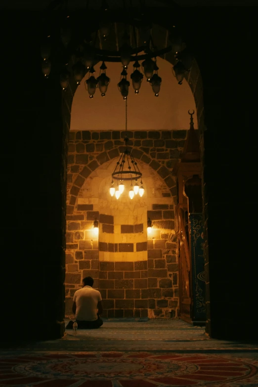 a person sitting in an entrance way at night
