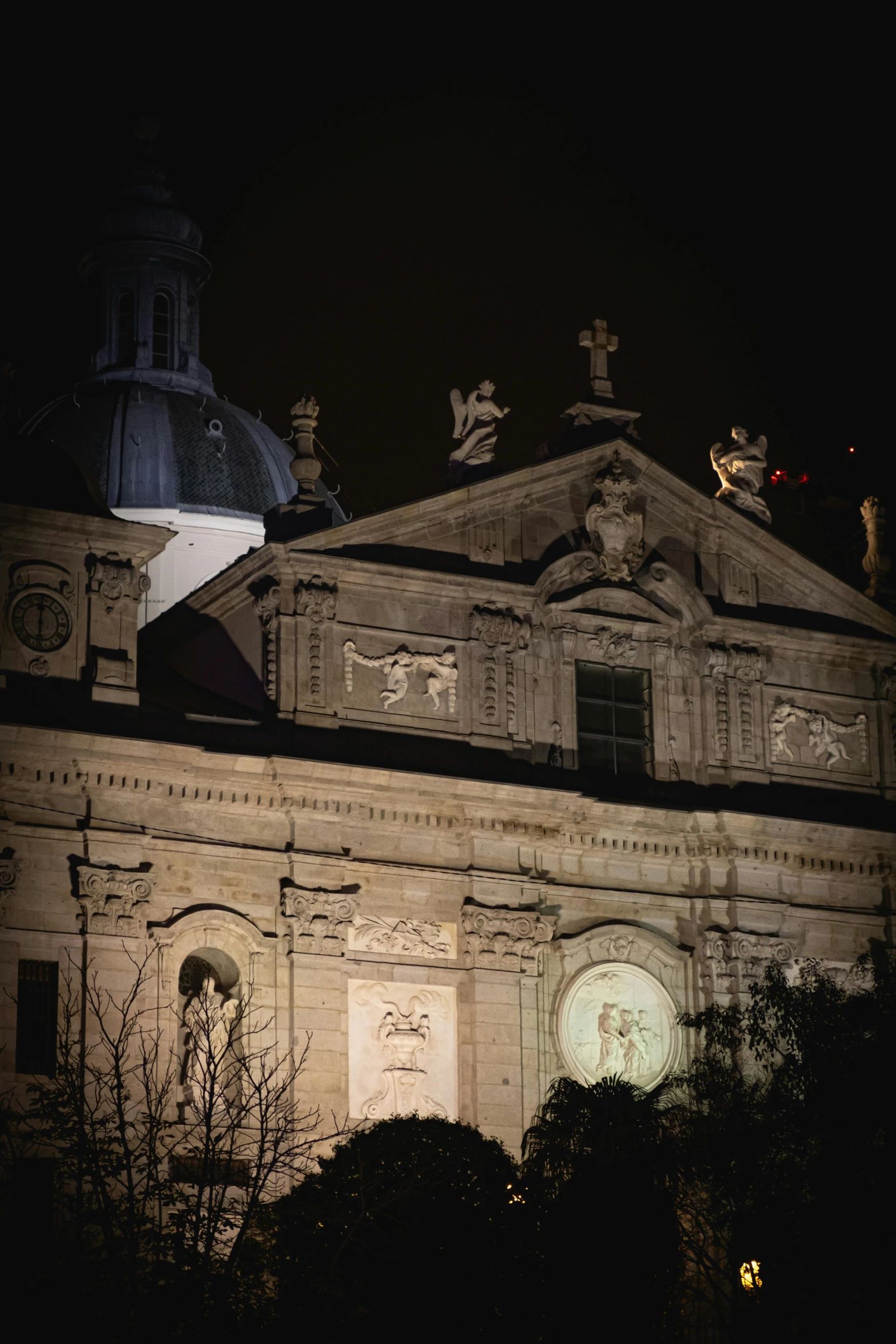 a building lit up at night with an open roof and steeple