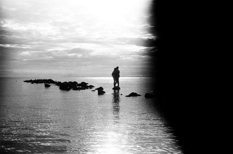 a man is standing at the shore with his surfboard