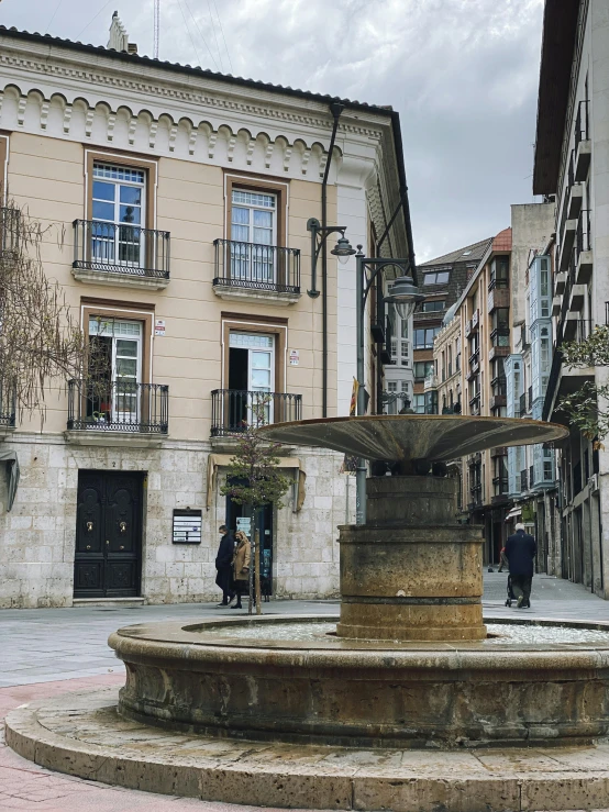 a fountain sits in the middle of a courtyard