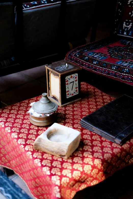 there is an old time clock on top of a red table