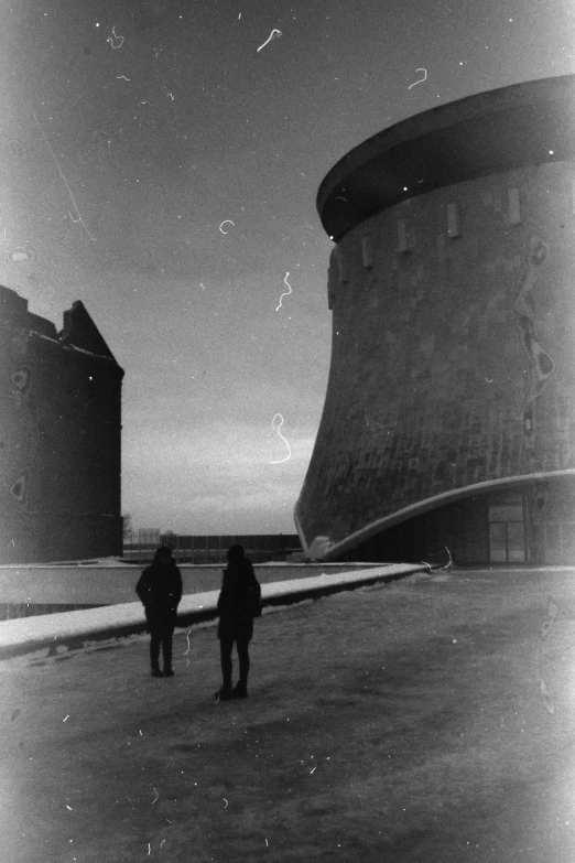 two people are walking outside in the dark