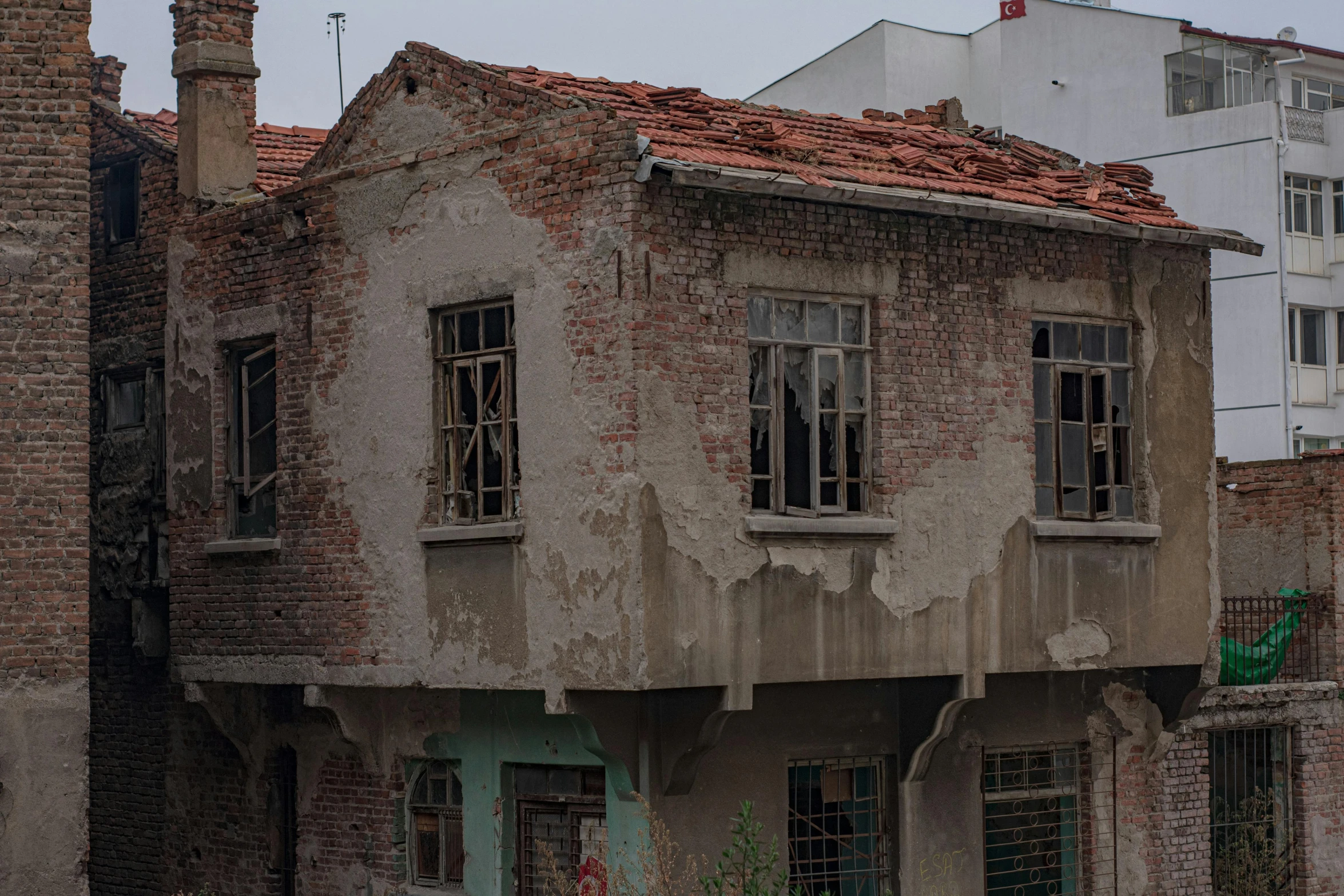 a dilapidated run down brick house with windows missing