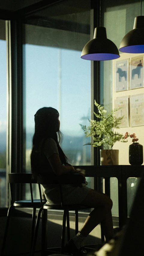 a woman sitting in a chair near a table