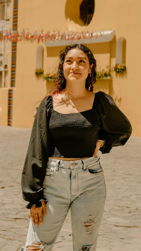a woman wearing ripped jeans and a black shirt