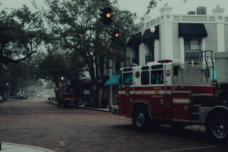 an old firetruck parked in front of a white house on the street