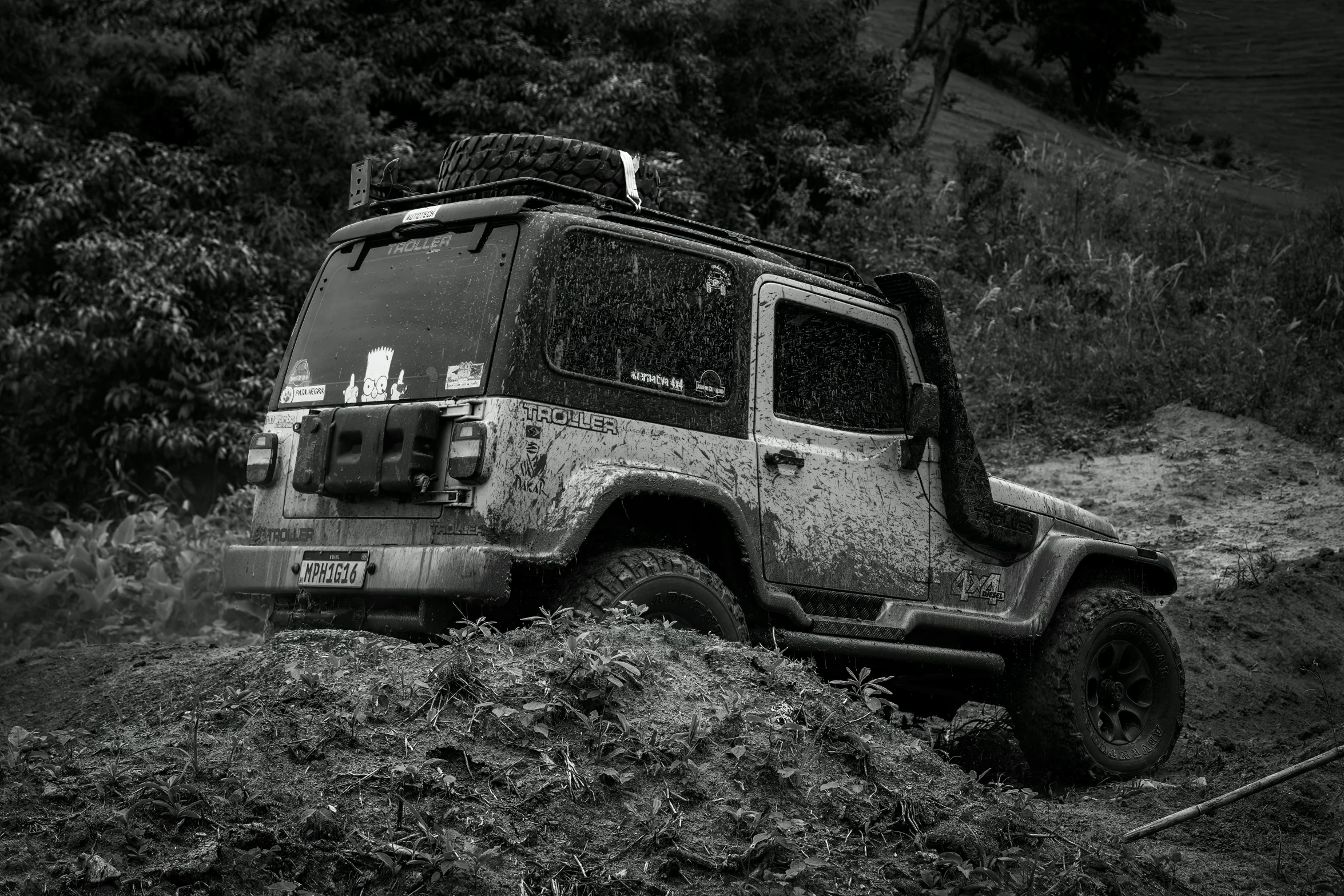 black and white po of the front end of a car on a muddy road