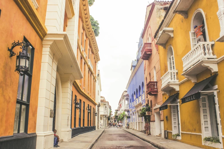 a street in an old city with yellow buildings