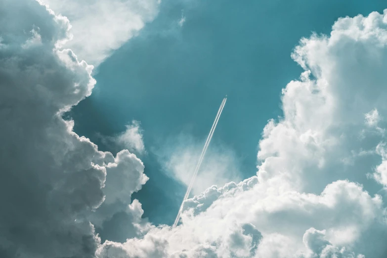 an airplane flying over some cloudy skies