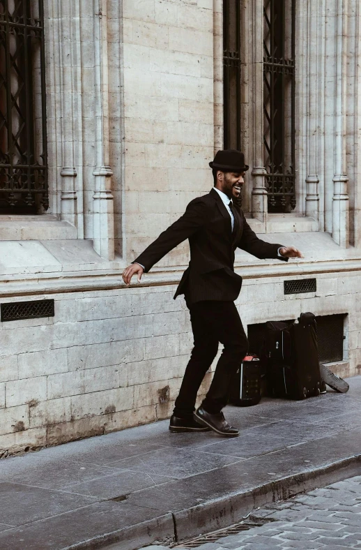 man in suit walking down an empty sidewalk with his luggage