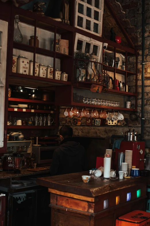 an old fashioned cafe with wooden shelves full of items